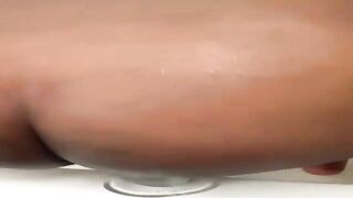 Black big beautiful woman is usinga large, glass sextoy during the time that masturbating in front of the camera