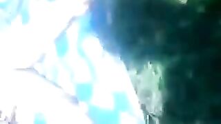 Woman sunbathing topless in grass