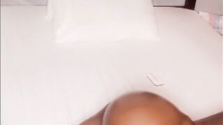 Afro woman rubbing and smacking oiled butt in daybed